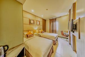 a hotel room with two beds and a television at Serela Merdeka by KAGUM Hotels in Bandung +41 photos