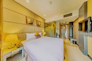 a bedroom with a large white bed and a bathroom at Serela Merdeka by KAGUM Hotels in Bandung