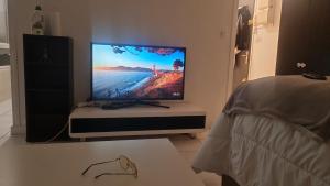 a flat screen tv sitting on a stand in a bedroom at RELAX Privacy in Sarcelles