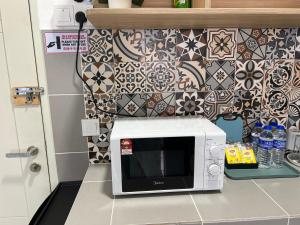 a microwave sitting on a counter in a kitchen at Homestay Kesidang in Seri Iskandar
