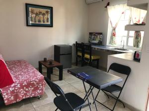 a small living room with a table and a kitchen at Casa Penélope in Puerto Ángel