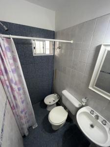 a small bathroom with a toilet and a sink at Los Manantiales in Villa Gesell