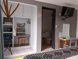 a bedroom with a bed and a bathroom with a toilet at Un Sueño Valle de Huajes in Oaxaca City