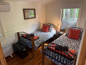 a small room with two beds and a window at Gladstone House in Beechworth