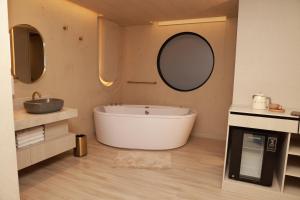 a bathroom with a tub and a sink and a mirror at VPV Suites & Casino in Medellín +99 photos