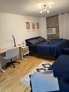 a bedroom with two beds and a desk with a computer at Oasis Retreat - Cozy studio in Union Square in New York