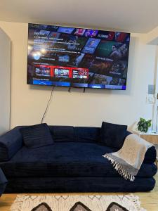 a blue couch in a living room with a flat screen tv at Oasis Retreat - Cozy studio in Union Square in New York