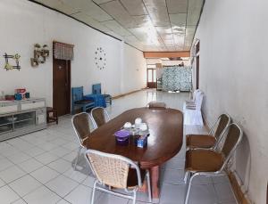 a dining room with a wooden table and chairs at Labore Homestay in Waha