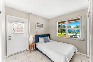 een slaapkamer met een bed en een raam bij 721 Java Rd in Cocoa Beach +43 foto's