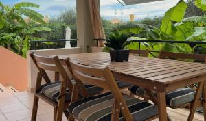 a wooden table and chairs on a balcony at Nefeli Beach Home with Hot Tub - 100m to Beach in Barbati