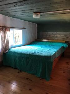 een groen bed in een kamer met een raam bij Complejo Las Tonas in Las Toninas