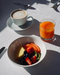 eine Schale Obst und eine Tasse Kaffee auf dem Tisch in der Unterkunft Grand Dilly Inn Saigon Hotel - Ben Thanh Market in Ho-Chi-Minh-Stadt + 9 Fotos