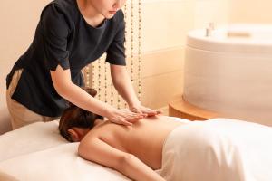 a woman performing acupuncture on a womans abdomen at JW Marriott Hotel Shenzhen in Shenzhen