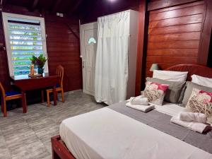 a bedroom with a bed and a table and a window at Domaine de Lauréal in Le Moule