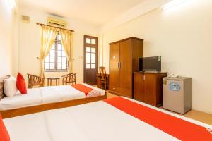 a hotel room with two beds and a television at Cửa Đại Beach Hotel in Hoi An