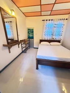 Pineapple Surf Villa في آهانغاما: غرفة نوم بها سرير ومرآة