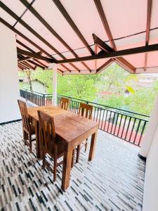 Pineapple Surf Villa في آهانغاما: طاولة وكراسي خشبية على سطح السفينة