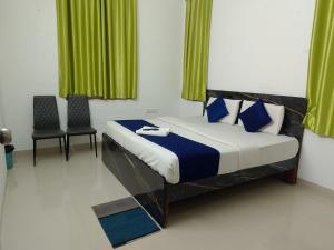 Un dormitorio con una cama con dos sillas y cortinas verdes. en Luxury Villa Rooms Phamacity Genome Valley, en Turkapally