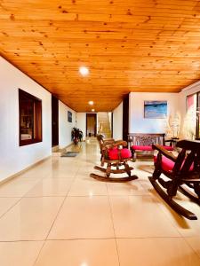 uma sala de estar com tectos e mesas e cadeiras em madeira em Cabaña Valle De La Laguna, jacuzzi y vista al Lago em Aquitania