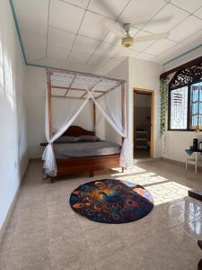 a bedroom with a canopy bed and a rug at Villa Sama Mandira in Ranna