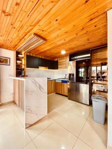 uma cozinha com tecto em madeira e um balcão em Cabaña Valle De La Laguna, jacuzzi y vista al Lago em Aquitania