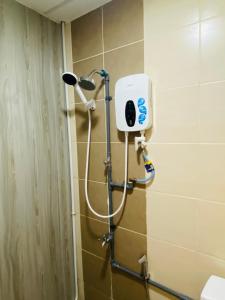 eine Dusche im Bad mit einem Seifenspender an der Wand in der Unterkunft Majestic Manhattan Suites ITCC in Penampang