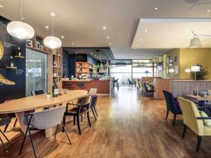 a restaurant with tables and chairs and a cafeteria at Mercure Hotel Mannheim am Rathaus in Mannheim