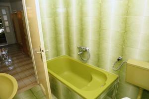 a bathroom with a green tub and a toilet at Apartments Jozica in Brna - Insel Korcula 6371 in Brna