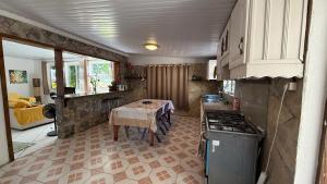 a kitchen with a table and a stove in it at Ave Surfing House in Mahina +8 photos