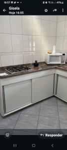 a kitchen with a stove and a microwave at Maitinga, a little paradise in Bertioga