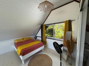 a small bedroom with a bed and a window at Ave Surfing House in Mahina