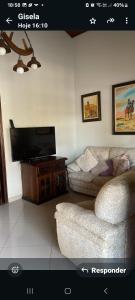 a living room with a couch and a flat screen tv at Maitinga, a little paradise in Bertioga
