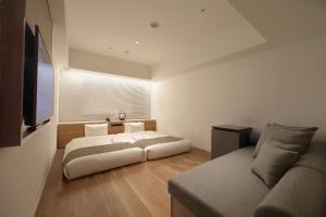 una camera da letto con un letto e un divano di ORIENTAL HOTEL KYOTO ROKUJO a Kyoto