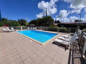 a swimming pool with chaise lounge chairs next to it at Domaine de Lauréal in Le Moule