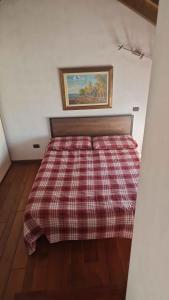 a bedroom with a bed with a plaid blanket at Holiday home in Madonna Del Sasso 22866 in Madonna del Sasso +17 photos