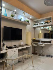 Una sala de estar con un televisor de pantalla plana en una pared. en Shell Residences near MOA and NAIA by Mae, en Manila