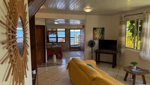 a living room with a couch and a television at Ave Surfing House in Mahina