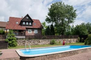 a house with a swimming pool in front of a house at Chalupa nad Popelkou in Lomnice nad Popelkou