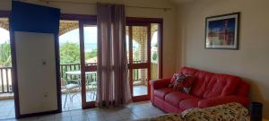 a living room with a red couch and a balcony at Praia Brava Apto 2 dorms Vista ao Mar in Florianópolis