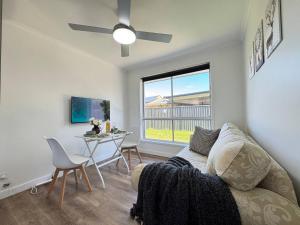 a living room with a couch and a table and a window at Studio in Belmont | Easy to City & Airport in Brisbane