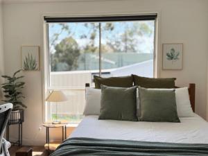 a bed in a bedroom with a large window at Studio in Belmont | Easy to City & Airport in Brisbane