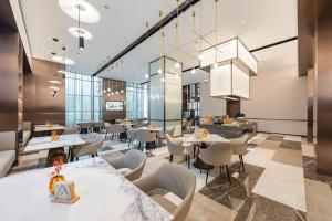 a dining room with tables and chairs and a restaurant at Atour Hotel Jiading Nanxiang in Jiading