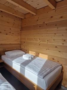 una camera da letto con un letto in una stanza di legno di Kozara Panoramic Resort a Bosanska Gradiška