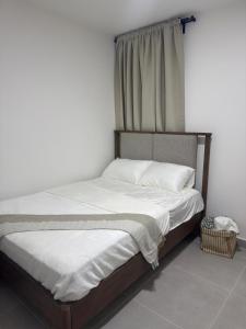 een slaapkamer met een bed met witte lakens en een raam bij Palmera 402 in Punta Cana