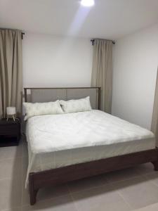 een slaapkamer met een groot bed met witte lakens bij Palmera 402 in Punta Cana