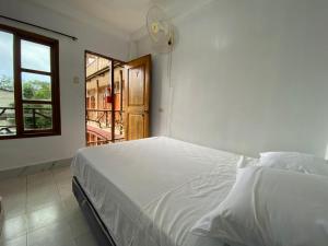 a bedroom with a white bed and a window at Tierra y Mar in Montañita