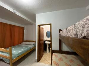 a bedroom with a bunk bed and a sink at Tierra y Mar in Montañita