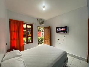 a bedroom with a bed and a television on the wall at Tierra y Mar in Montañita +30 photos