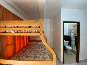 a bunk bed in a small room with a toilet at Tierra y Mar in Montañita