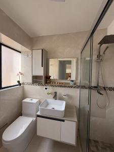 um banheiro com vaso sanitário, pia e chuveiro em Oceanfront Playa Grande 10 min Airport Aeropuerto em Maiquetía